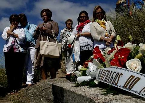 Familiares de los desaparecidos ante la ofrenda floral realizada ayer en el Cabo Fisterra. 