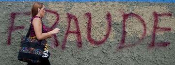 Una mujer pasa por delante de un muro con una pintada alusiva a las irregularidades en las elecciones ganadas por Maduro.