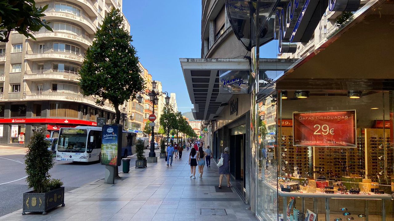 Varias personas pasean en una jornada de sol en la calle Ur�a de Oviedo