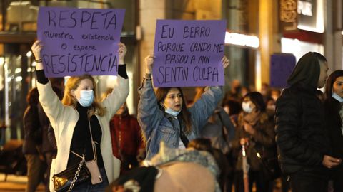 Dos jvenes sostienen pancartas reivindicativas en Vigo.