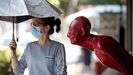 Una mujer, con máscara en una calle de Bangkok, en Tailandia