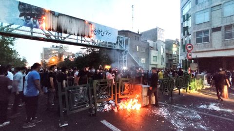 Los manifestantes prenden fuego a una barricada durante una protesta por la muerte de Mahsa Amini, el pasado septiembre, en Teherán