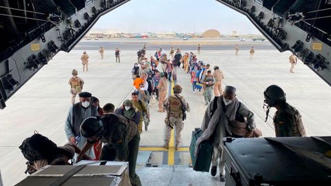 Militares españoles y ciudadanos afganos subiendo a bordo de un avión militar para ser evacuados de Afganistán