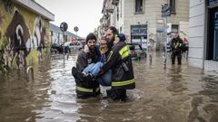 Técnicos de emergencias italianos rescatan a una mujer en las inundaciones de Isola (Milán) ocurridas a finales de octubre