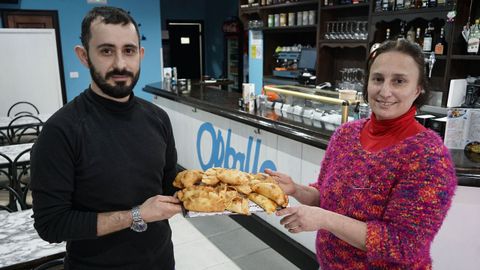 Ángel y Nadia, sosteniendo una bandeja de sus empanadas argentinas, en Orballo, en A Rúa