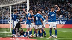 Los jugadores del Real Oviedo en el derbi, mientras Chris Ramos es atendido en el suelo