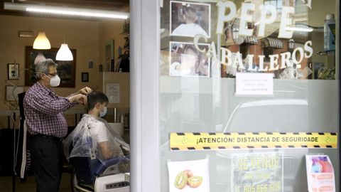 Jos Mara Barreiro corta el pelo a un cliente en la Peluquera Pepe de Sigeiro (Oroso)
