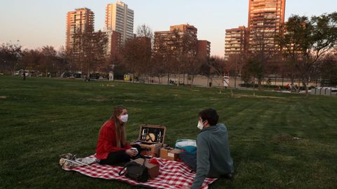 Una pareja disfruta de un picnic en un parque, mientras que algunos ayuntamientos locales pueden aliviar las restricciones de cierre durante el brote de la enfermedad por coronavirus, en Santiago, Chile