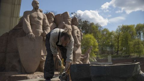Un obrero retira las ultimas piezas de una estatua conmemorativa de la amistad entre Ucrania y Rusia, en Kiev.