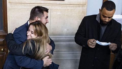 Una empleada del tren Thalys abraza al estadounidense Alek Skarlatos, que espera con Anthony Sadler su entrada en la sala donde tiene lugar el  juicio por ataque terrorista