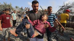 Un hombre lleva en brazos a un niño salvado de los escombros de un edificio destruido por un ataque israelí a Gaza.