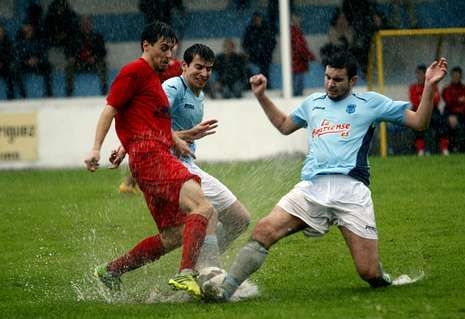 Carlos y Alberto intentan robar el bal�n a un jugador sarriano.