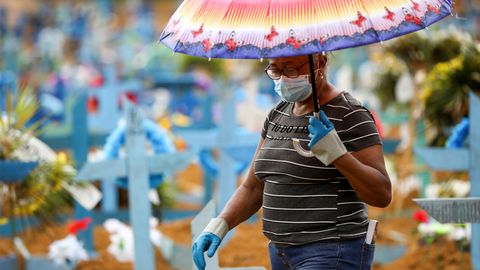 Una mujer camina entre tumbas en un cementerio dedicado al covid-19 en Manaus, Brasil