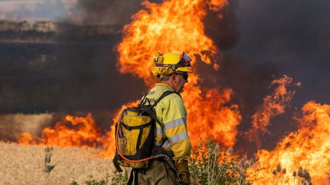 Un bombero observa las llamas del incendio declarado este domingo en Quintanilla del Coco, en Burgos, que obligó a evacuar el monasterio de Santo Domingo de Silos