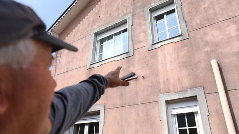 Un vecino seala el impacto de bala que uno de los tiros dej en la fachada de la vivienda