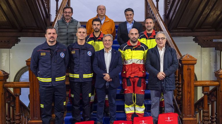 Tres de los bomberos que fueron a Valencia, con la funda amarilla, fueron recibidos en la Diputación por su presidente y otros cargos políticos y mandos del consorcio provincial de incendios.