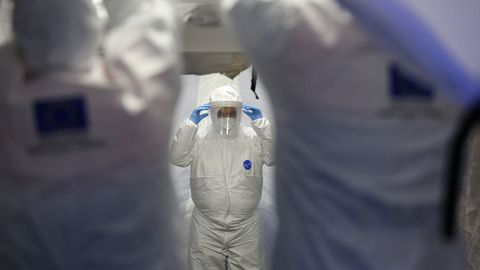Trabajadores de proteccion civil se desinfectan contra el coronavirus en una carpa instalada en el hospital del PTS de Granada
