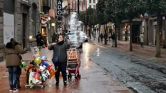 Una vendedora sujeta los globos arrastrados por el temporal de viento, en Oviedo.Una vendedora sujeta los globos arrastrados por el temporal de viento, en Oviedo