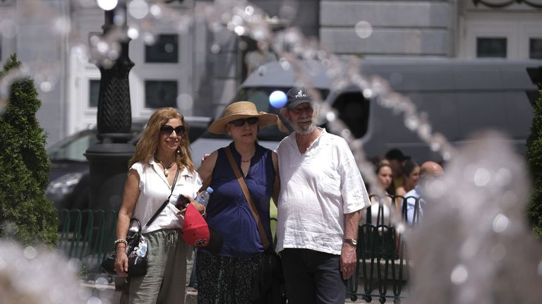 Unos turistas se fotografían delante de la fuente de La Escandalera, al lado del Teatro Campoamor de Oviedo
