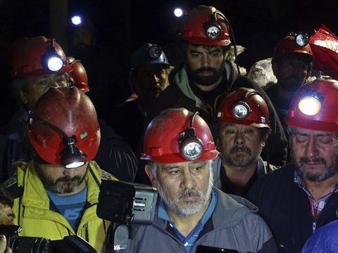 Un grupo de mineros se reunen después de su salida de la mina Santa Ana donde se encontraban atrincherados a 650 metros de profundidad en un pique de carbón en la localidad sureña chilena de Curanilahue situado a 639 kilómetros al sur de Santiago de Chile, tras 43 días de huelga en demanda de mejoras salariales.