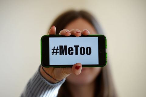 Una mujer sostiene un móvil con el lema MeToo