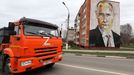 Un camión con la letra Z, que simboliza el apoyo a la invasión rusa, pasa por delante de un mural con la cara de Putin, en Moscú