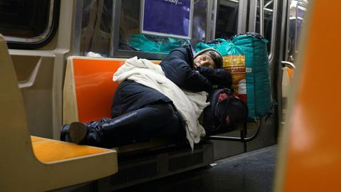 Una mujer duerme en el metro de Nueva York en plena pandemia