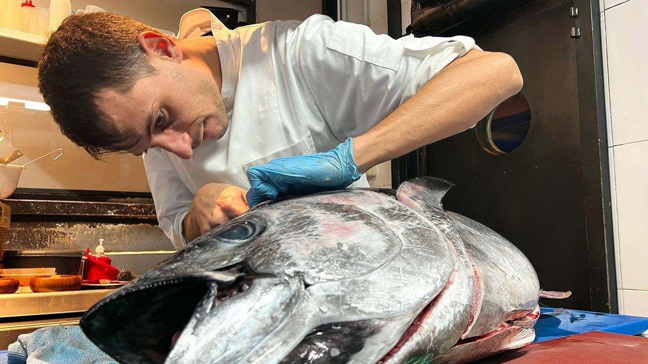 Adrián Albino Lamas, propietario y cocinero del restaurante Niño Corvo, tratando el atún.