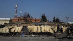 Una mujer pasa junto a los restos de un edificio daado por los bombardeos rusos en Barabashovo (Jrkov)