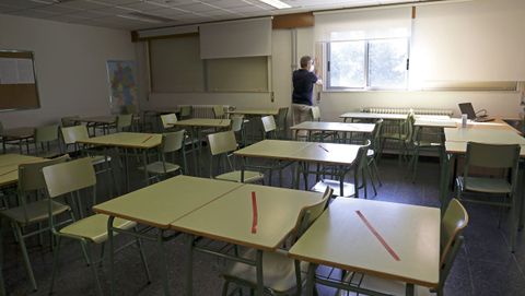 Un aula preparada para examen en la EOI de Santiago, con varias mesas inhabilitadas