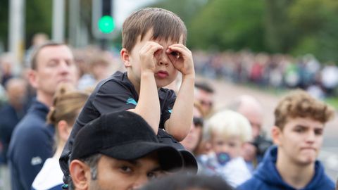 Un niño espera la llegada de la comitiva fúnebre en Dundee