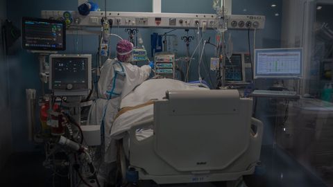 Trabajadores sanitarios atienden a un paciente en la unidad de cuidados intensivos del Hospital del Mar, en Barcelona