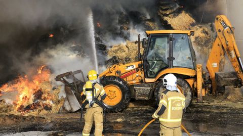 Una excavadora deshizo los montones de hierba que ardan para facilitar la extincin del fuego