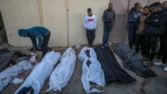 Un grupo de palestinos observa unos cadáveres en Gaza.