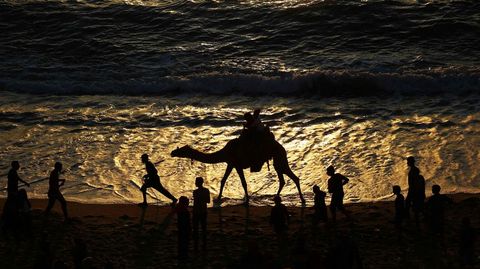 Ciudadanos palestinos disfrutan de una tarde en la playa en Gaza (Palestina).