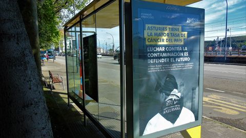 Una de las marquesinas de autob�s del Parque del Muelle con uno de los esloganes de Podemos Asturias