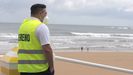 Un empleado de la empresa de Sereno de Gijón controla el acceso a la playa de San Lorenzo, este lunes en Gijón