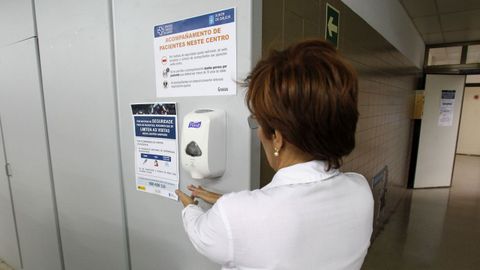 Una trabajadora del hospital se lava las manos con un dispensador de jabn y junto a unos letreros que advierten de las precauciones a adoptar por la epidemia