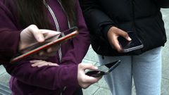 Adolescentes con sus teléfonos móviles en un instituto de Ribeira