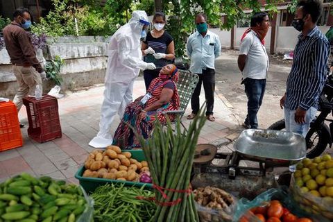 Sanitario realiza una prueba de coronavirus a una vendedora de alimentos en Ahmedabad, India