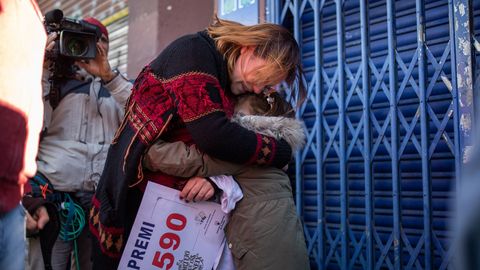 Una mujer abraza a su hija mientras sujeta el nmero que ha sido premiado con el gordo de la lotera, el 26590, en Barcelona 
