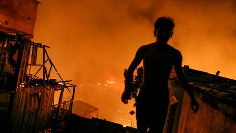Los residentes ayudan a los bomberos en las labores de extincin del fuego que rode la barriada de Educandos, en Manaus (Brasil)
