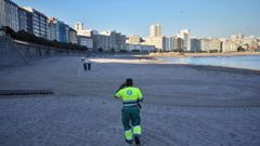 Un trabajador de la concesionaria de limpieza viaria, en la playa del Orzán