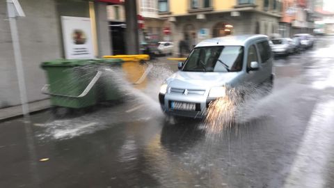 La calle Real de Muxa completamente inundada a causa de las fuertes lluvias
