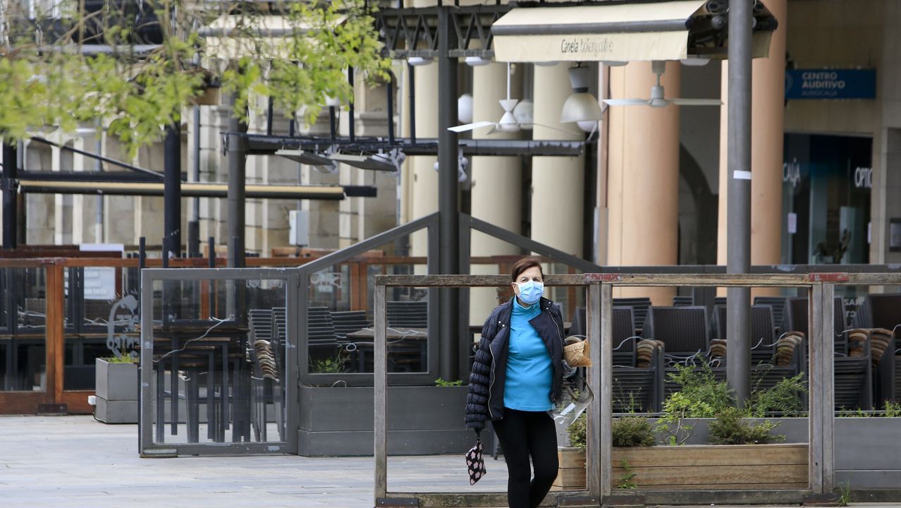 Un hombre con mascarilla pasea con su hija frente a la puerta del parador de turismo de Monforte, cerrado por la crisis del coronavirus