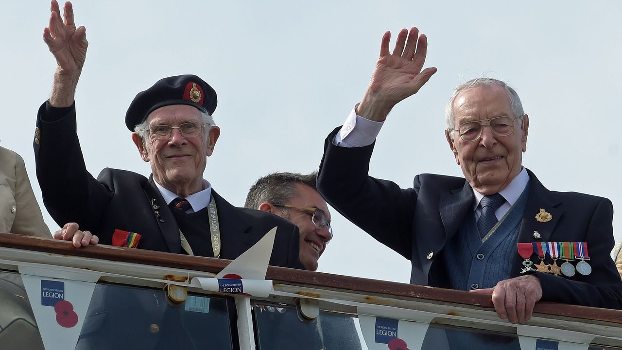 Veteranos britnicos de la Segunda Guerra Mundial saludan a su llegada a bordo del barco MV Boudicca al Puerto de Poole