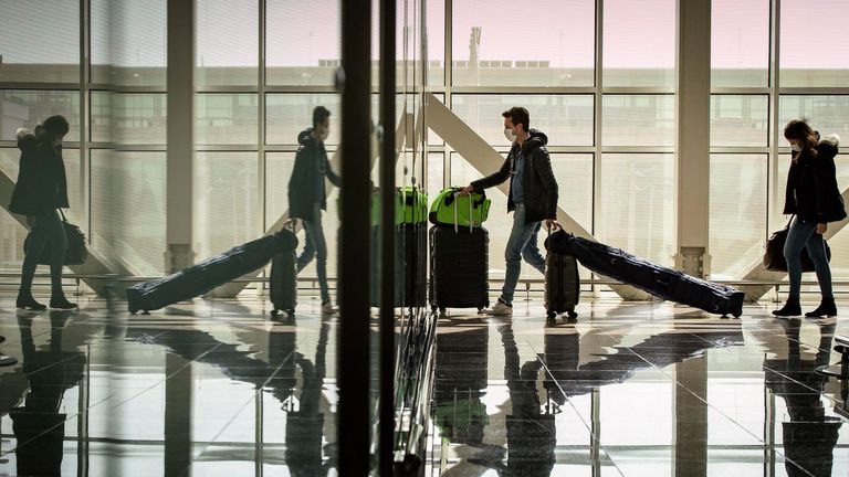 Varios pasajeros protegidos con mascarilla en una de las terminales del aeropuerto de Barcelona-El Prat