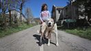 Eva y su perro Firuláis, junto a la casa familiar en la frontera gallega en la que se instaló