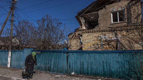 Una anciana camina en una zona arrasada por los bombardeos, en la ciudad Irpin, junto a la capital Kiev