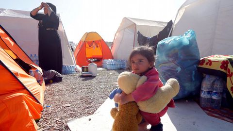 Un nio juega junto a una tienda de campaa en un campamento para damnificados en una localidad iran.